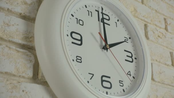 Zeitraffer innerhalb von zwölf Stunden. Runde weiße Uhr hängt an Ziegelwand. - Filmmaterial, Video