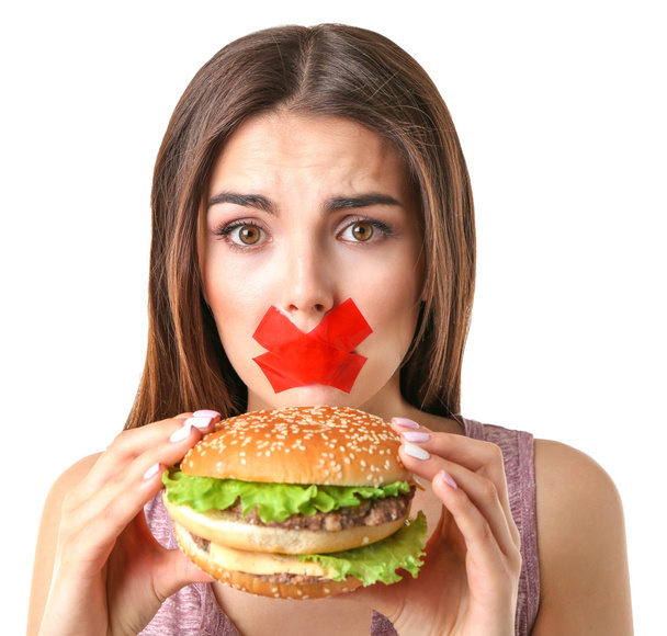 Woman with tied mouth holding hamburger - Foto, imagen