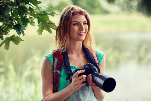 happy woman with backpack and camera outdoors - Фото, зображення
