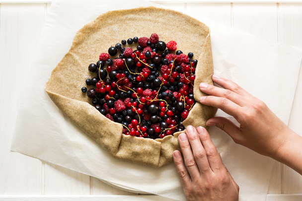 Homemade galette pie with red and black currants, blueberries and rapsberries. Top view - Fotó, kép