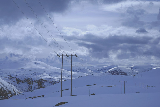 Power line on a snowy mountain - 写真・画像