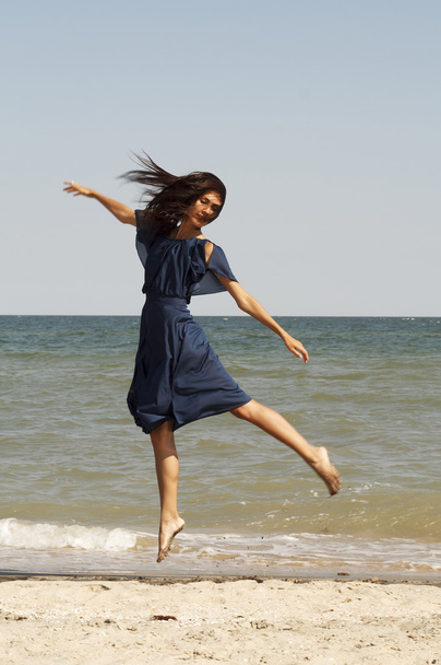 Young beautiful woman on the beach jumping - Фото, зображення