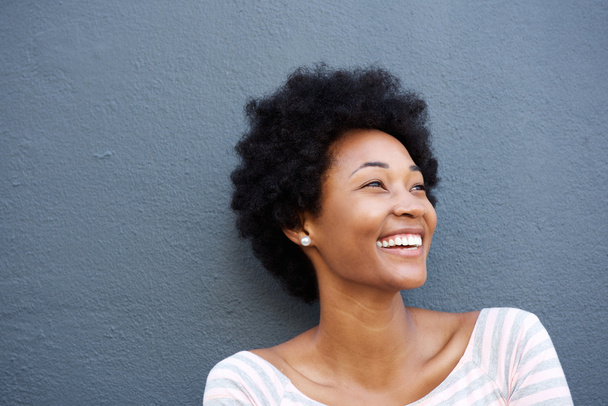 Крупним планом усміхнена жінка на сірій стіні
 - Фото, зображення