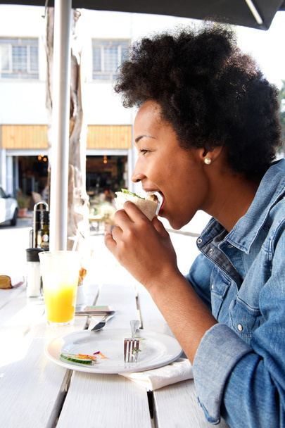 Joven mujer africana comiendo sándwich
 - Foto, imagen