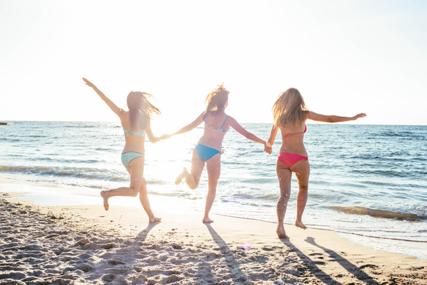 τρία κορίτσια που έχει τη διασκέδαση στην παραλία - Φωτογραφία, εικόνα