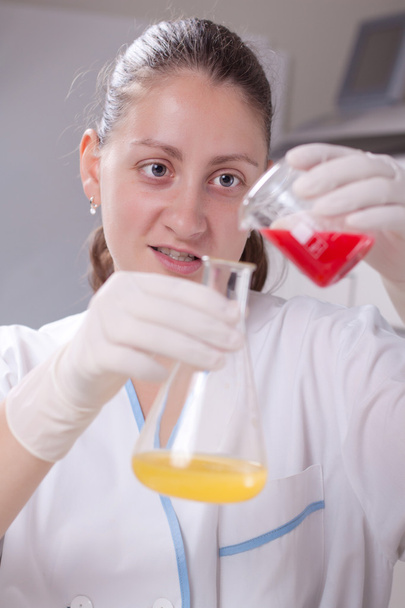 Mujer examinar colorido botellas llenar con productos químicos
 - Foto, Imagen