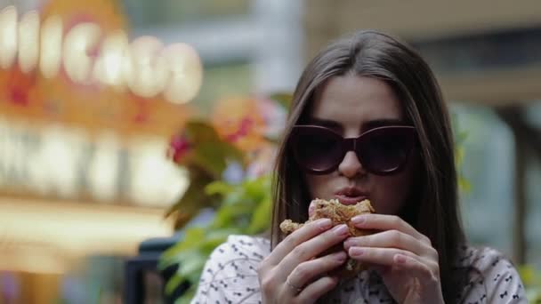 Beautiful Girl Eats Burger on the Street in Chicago - Materiał filmowy, wideo