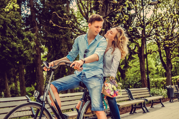 Радостная пара позирует на одном велосипеде
. - Фото, изображение