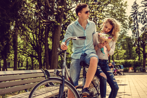 Joyfull couple posing on one bicycle. - Foto, immagini