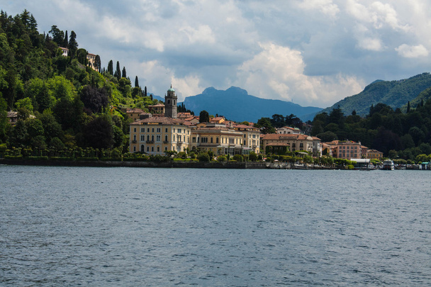 View on coast line of Lake Como, Italy, Lombardy region. Italian landscape, with Mountain and city with many colorful buildings on the shore - Foto, Bild