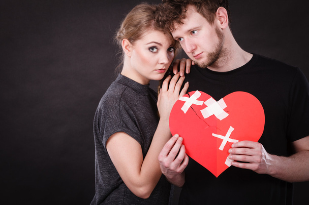 Sad couple holds broken heart - Фото, зображення