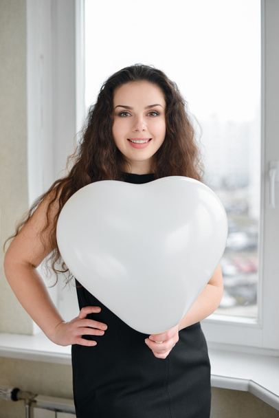 Attractive caucasian woman holding a baloon heart - Foto, Imagen