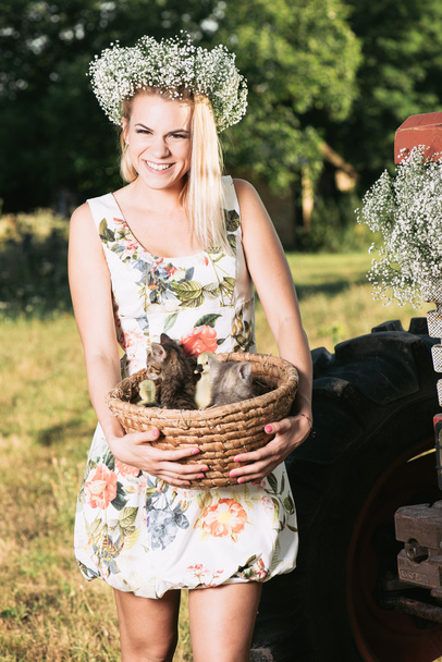 Joven, feliz agricultor mujer celebración cesta con lindo gatito y gansos
 - Foto, imagen