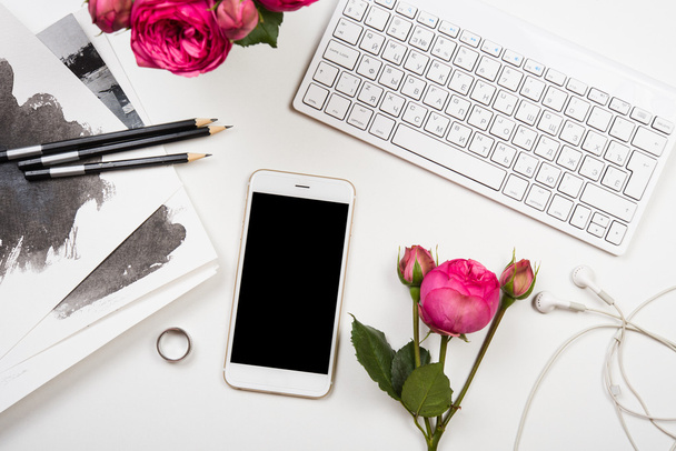 älypuhelin, tietokoneen näppäimistö ja fesh vaaleanpunaisia kukkia valkoinen välilehti
 - Valokuva, kuva