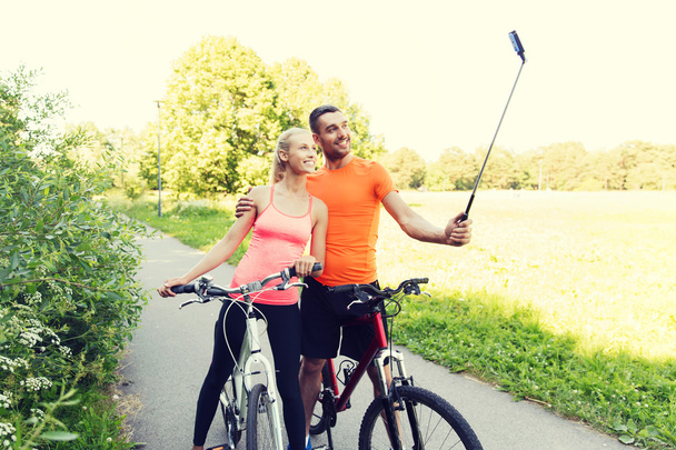 couple with bicycle and smartphone selfie stick - Photo, Image