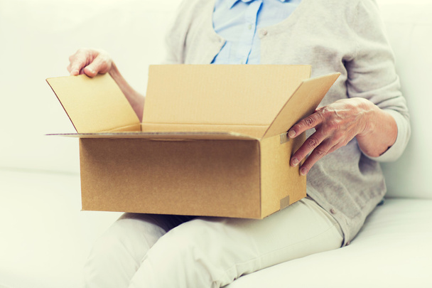 close up of senior woman with parcel box at home - Фото, изображение