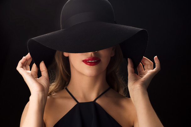 beautiful woman in black hat over dark background - Fotoğraf, Görsel
