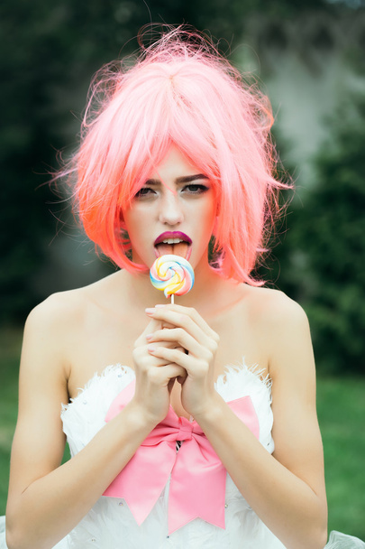 woman with orange hair lick lollipop - Foto, afbeelding