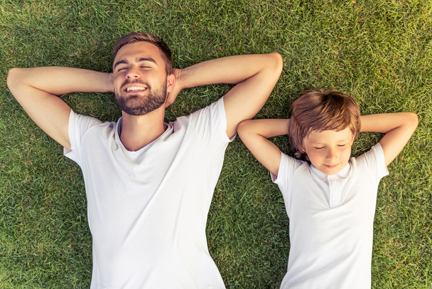 Dad and son resting outdoors - Foto, afbeelding
