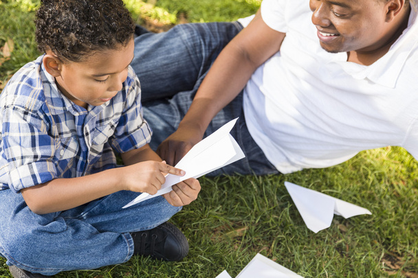 karışık ırk baba ve oğul kağıt uçaklar ile oynama - Fotoğraf, Görsel