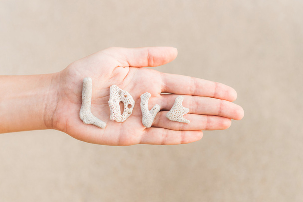Palavra de amor feito de conchas na mão
 - Foto, Imagem