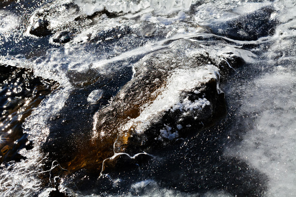 Suelo congelado con pequeña roca y charco de hielo en la mañana de invierno
 - Foto, Imagen
