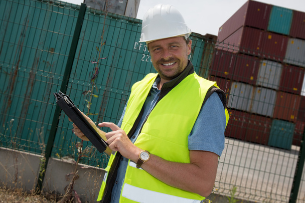 Gelukkig man logistiek manager bij container overslag plant, met tablet - Foto, afbeelding