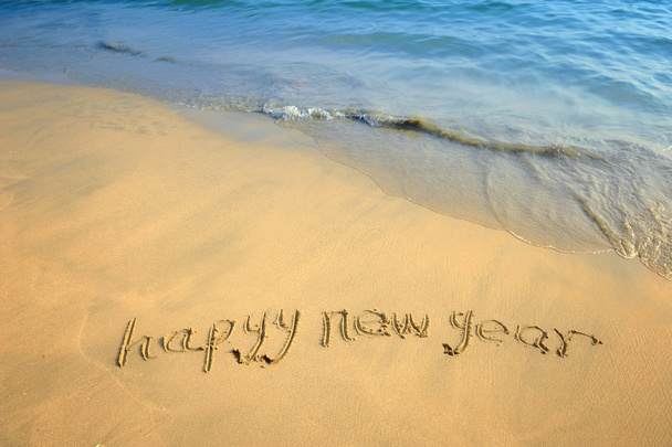 Happy new year written in the sand - Foto, afbeelding