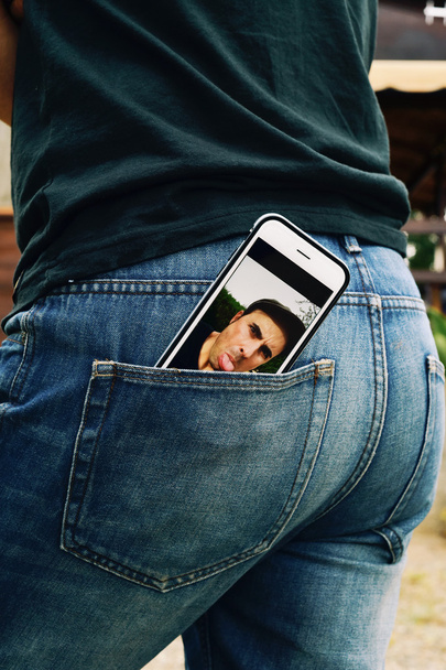 man sticking his tongue out in a smartphone - Photo, Image
