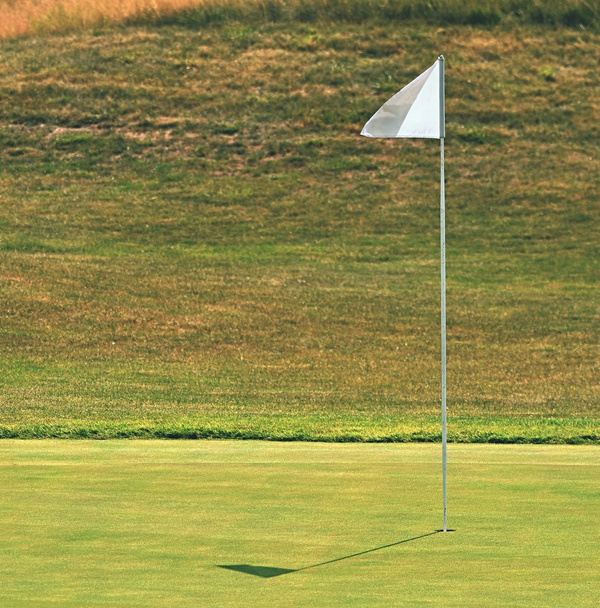 Nice golf course on a sunny summer day. Hole with a flag. Popular outdoor sport. - Photo, Image