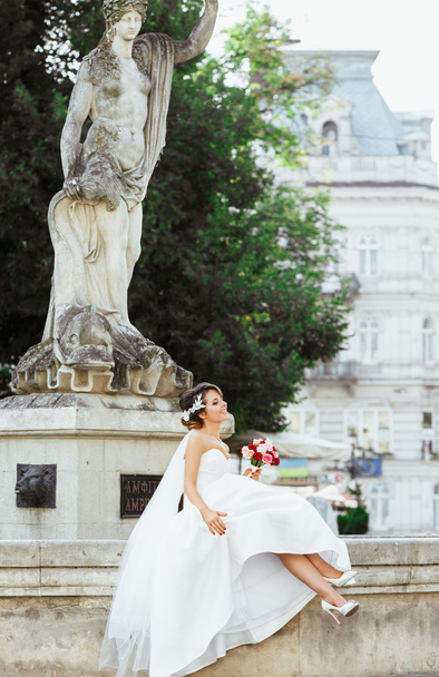 Гарна наречена сидить біля пам'ятника
 - Фото, зображення