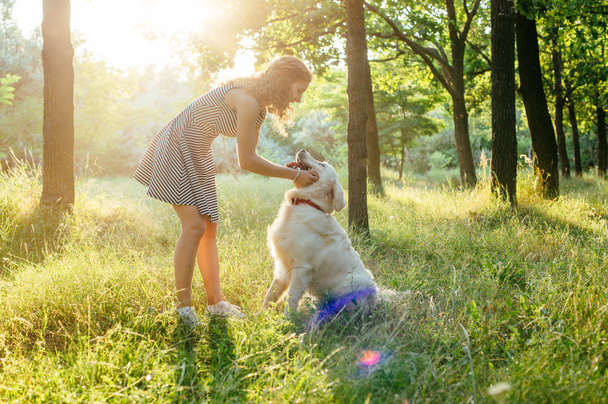 girl playing with dog in park - Фото, зображення