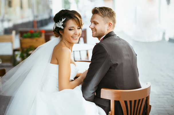 Braut und Bräutigam sitzen auf Stühlen - Foto, Bild