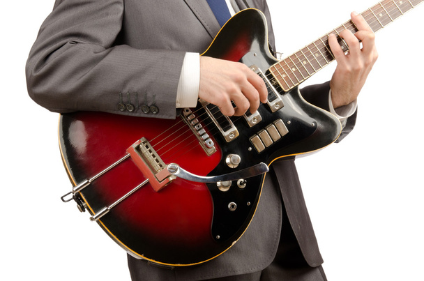 Guitar player in business suit on white - Photo, image