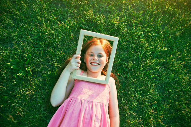 Smiling girl with wooden frame  - Foto, Imagem