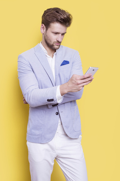 Knappe elegante man met een telefoon in zijn hand - Foto, afbeelding