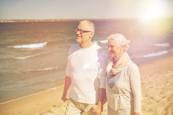 feliz pareja de ancianos caminando a lo largo de la playa de verano
 - Foto, imagen