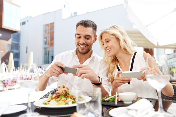 happy couple with smatphone photographing food - Фото, изображение