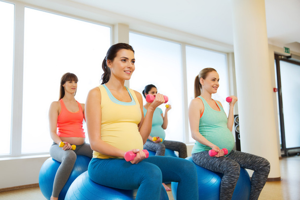 happy pregnant women exercising on fitball in gym - Foto, Bild