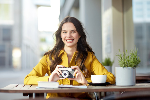 happy tourist woman with camera at city cafe - Фото, изображение