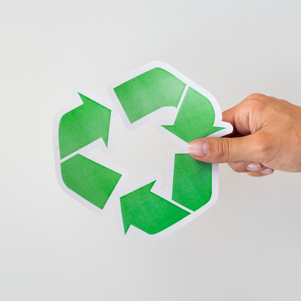 close up of hand holding green recycle symbol - Foto, afbeelding
