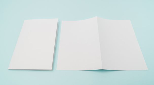 Bifold white template paper on blue background . - Foto, imagen