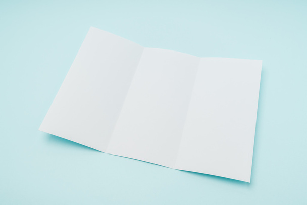 Trifold white template paper on blue background . - Foto, immagini