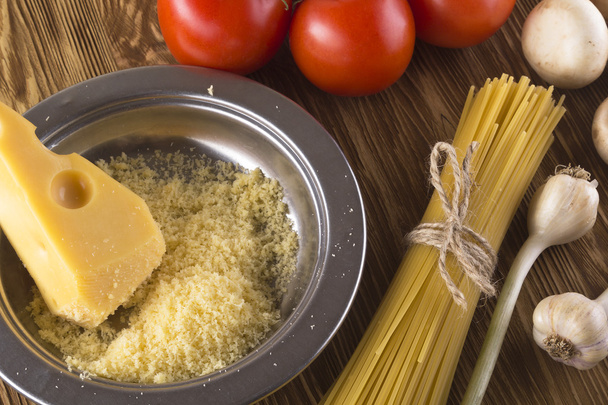 Pasta, tomatoes, garlic, champignon and grated cheese. - Photo, Image