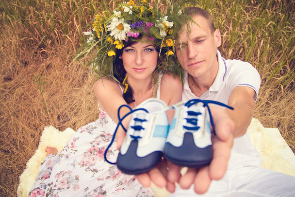 A couple in love during pregnancy in the park with young Sneaker - 写真・画像