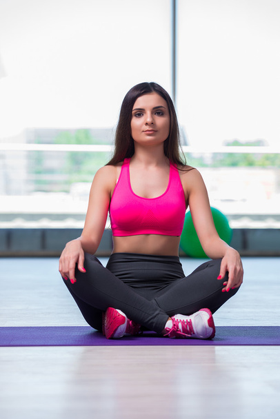 Молодая женщина медитирует в концепции здоровья спортзала
 - Фото, изображение