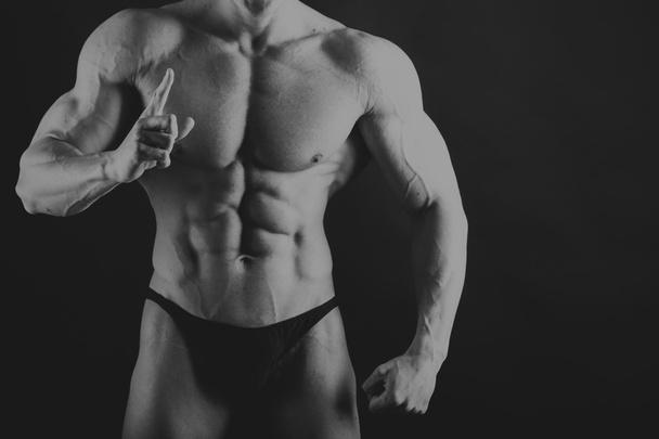 Beautiful muscular body on black - Photo, Image