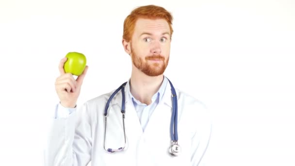 Lachende arts tonen van groene appel aan de camera - Video