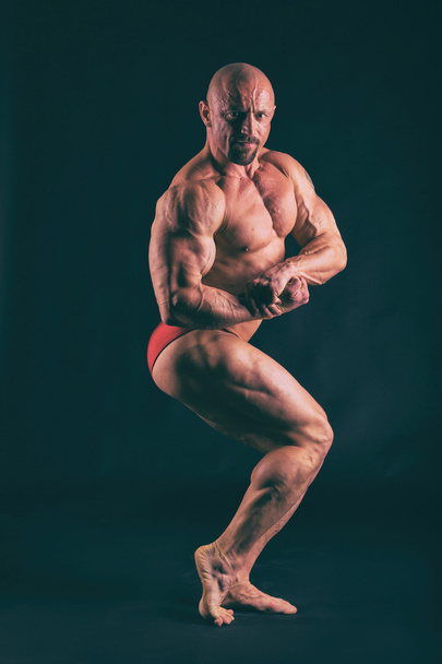 Bodybuilding, sterke man op zwart - Foto, afbeelding