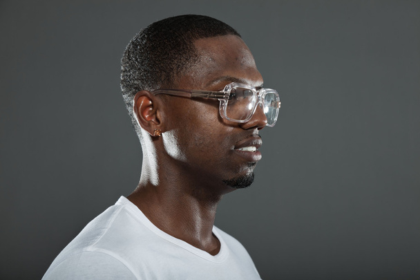 Cool urbano elegante hombre negro americano. Retrato de estudio de moda aislado sobre fondo gris. Usar gafas retro
. - Foto, Imagen